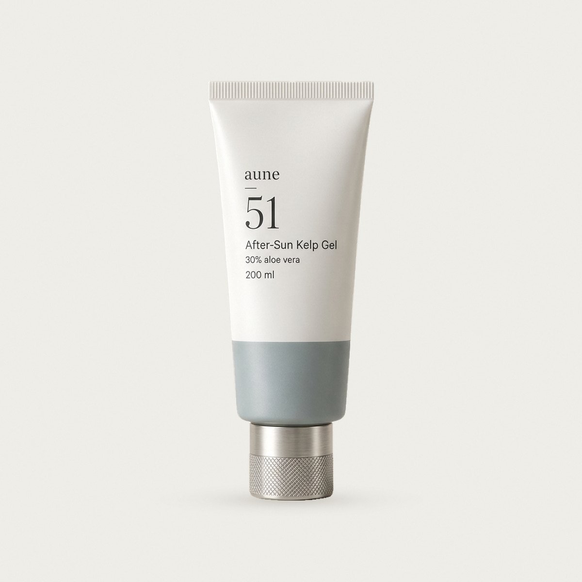 After-Sun Kelp Gel in a white glass tube with a sea-grey tide line, on a warm white backdrop