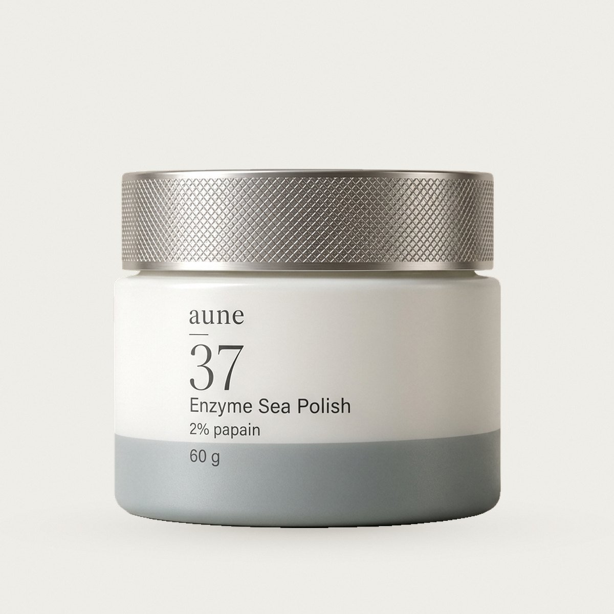 Enzyme Sea Polish in a white glass cream jar with a sea-grey tide line, on a warm white backdrop