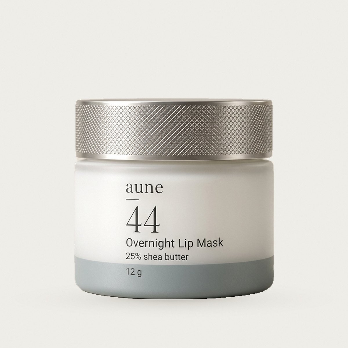 Overnight Lip Mask in a white glass small jar with a sea-grey tide line, on a warm white backdrop