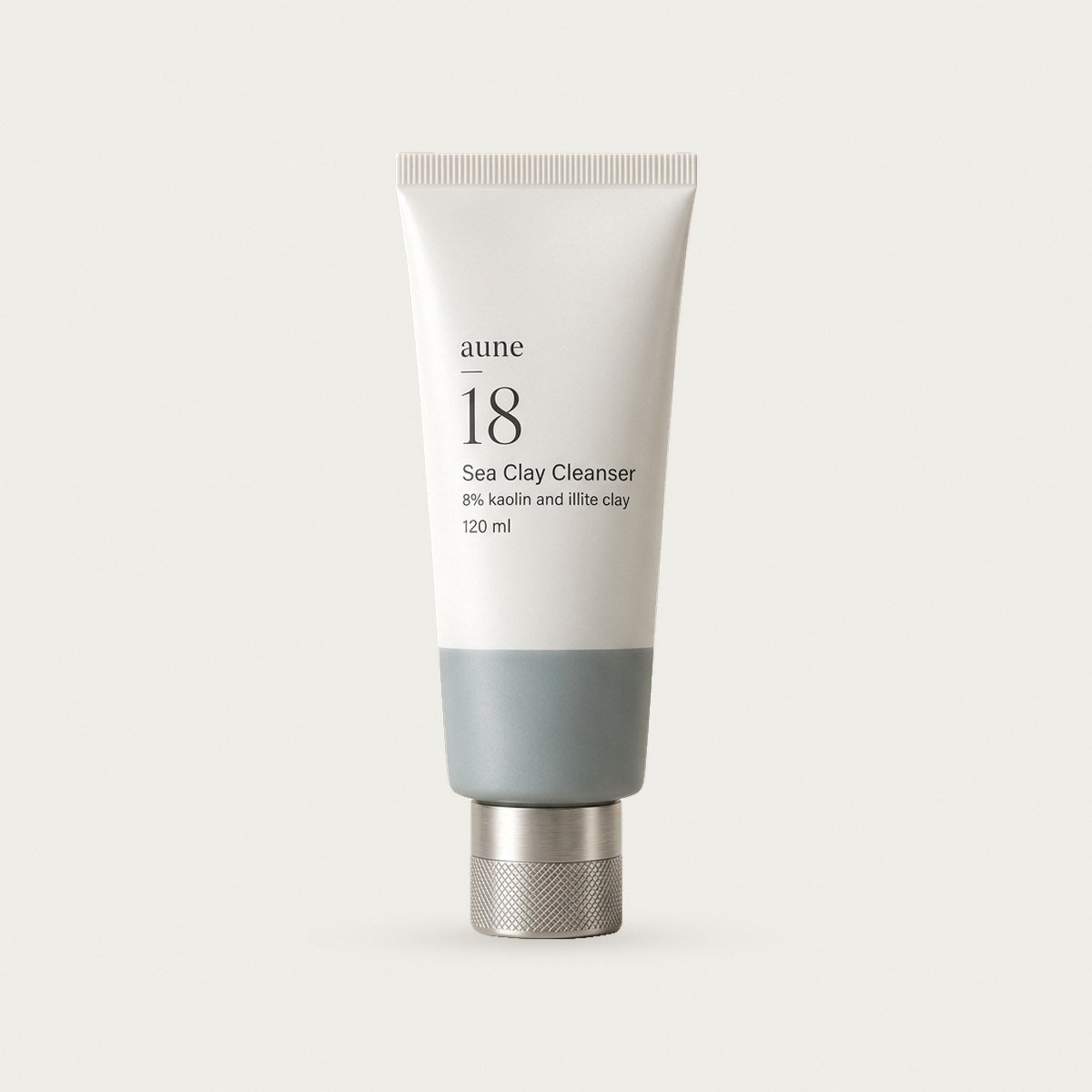 Sea Clay Cleanser in a white glass tube with a sea-grey tide line, on a warm white backdrop