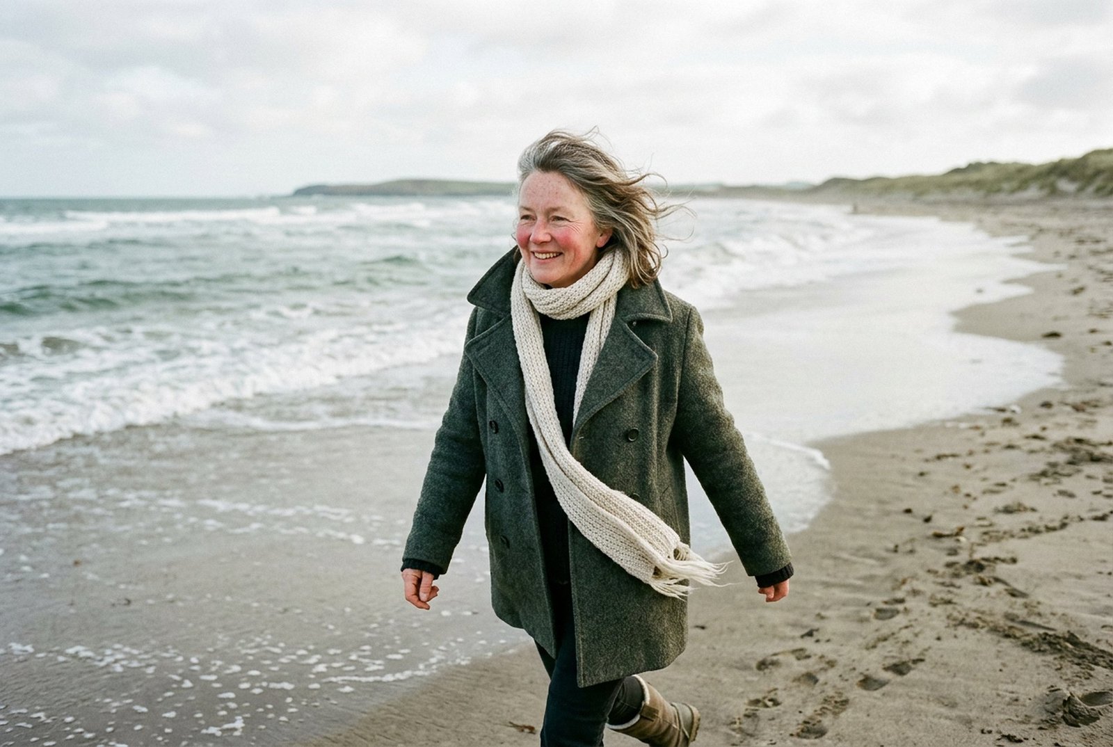 Walking on a windswept winter beach in a wool coat